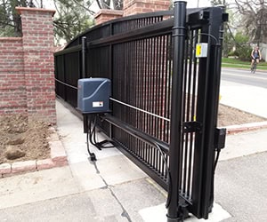 Automated black gate with motorized opener, showcasing installation for enhanced security and convenience in garage door services.