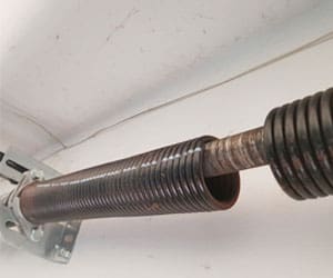 Garage door torsion spring system, highlighting the spring mechanism used in garage door repairs and installations.