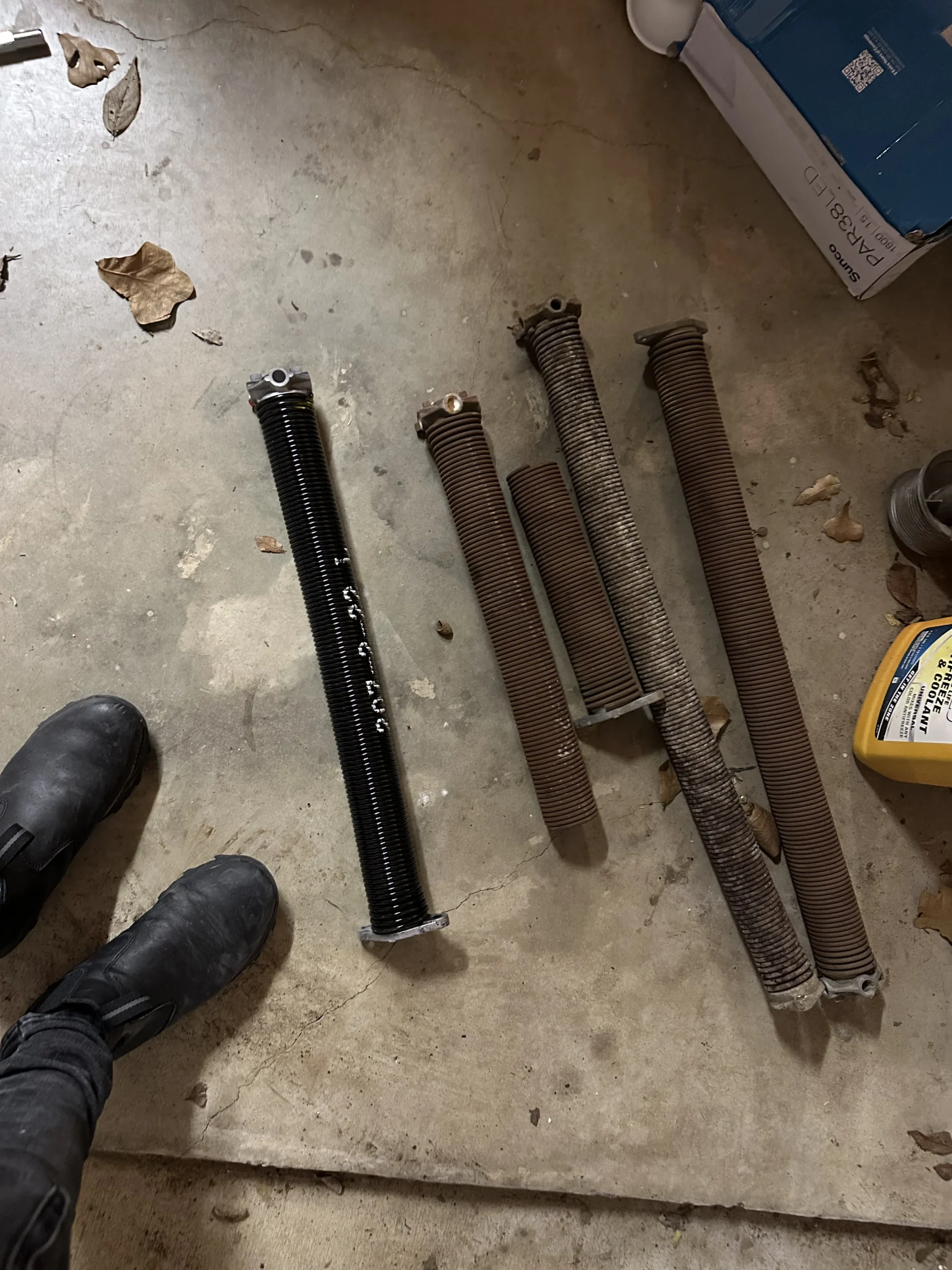 Close-up of a malfunctioning garage door showing broken spring and misaligned tracks